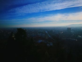 Aerial view of city against cloudy sky