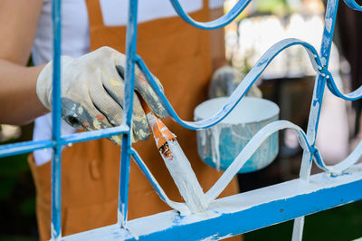 Close-up of man working on blue metal