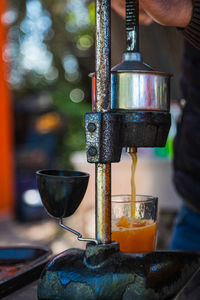 Close-up of a man crushes juice from a fresh bright orange. cooking freshly squeezed orange 