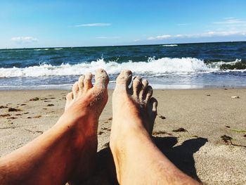 Low section of person relaxing at beach