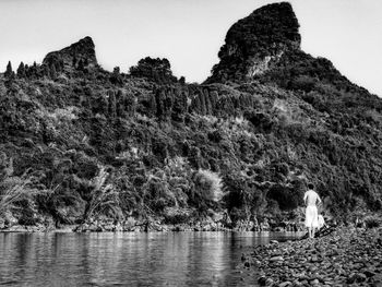 Rear view of man on rock against sky