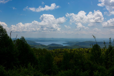 Scenic view of mountains and river against cloudy sky