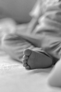 Close-up of baby boy lying on bed at home