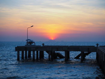 Silhouette pier on sea against sky during sunset