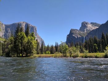 Scenic view of river and mountains against clear sky