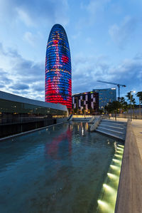 Illuminated city buildings against sky