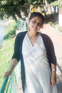 Portrait of smiling young woman standing outdoors