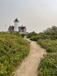 Lighthouse by sea against sky