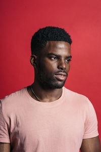 Portrait of young man against red background