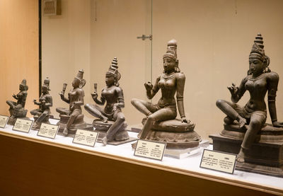 Statues on table against wall