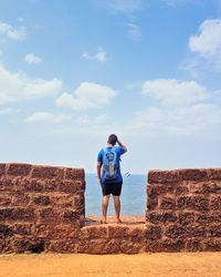 Rear view of woman standing on rock