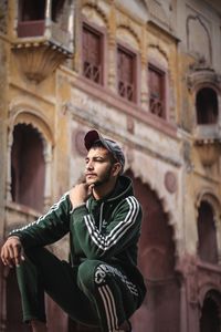 Young man standing against historic building