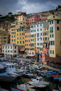 Boats moored at harbor against buildings in city