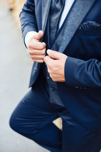 Midsection of person holding umbrella standing outdoors