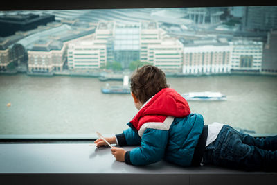Rear view of boy sitting in bus