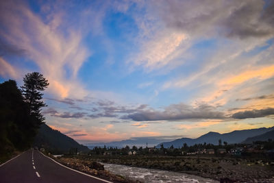 Empty road against sky during sunset