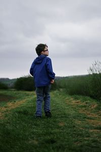 Rear view of boy standing on field