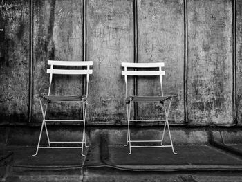 Empty chair on table against wall