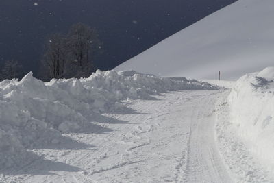 Snow covered landscape against sky