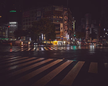View of shibuya crossing in tokyo during rainy season at night
