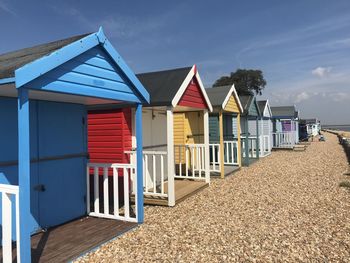 Multi colored houses on beach by buildings against sky