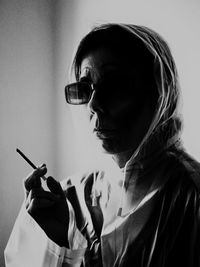 Close-up of woman wearing sunglasses holding cigarette