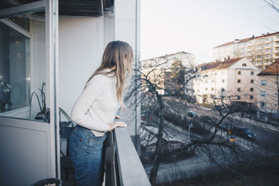 Woman standing by buildings in city