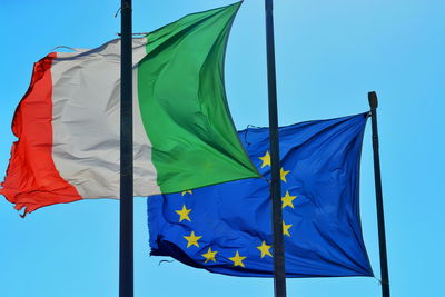 Low angle view of flag against blue sky