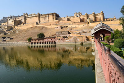 Arch bridge over river against buildings