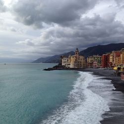 Scenic view of sea by buildings against sky