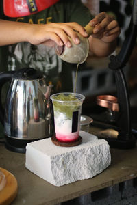 Cropped hand of person preparing food on table