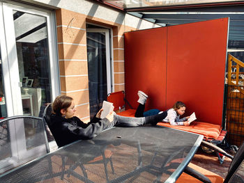 Siblings reading books in backyard