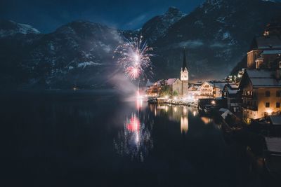 Firework display by buildings in city at night