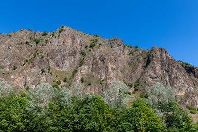 Scenic view of rocky mountains against clear blue sky