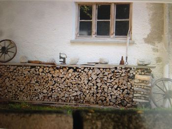 Stack of logs against building wall