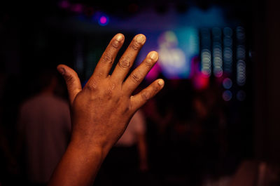 Close-up of hand gesturing at night