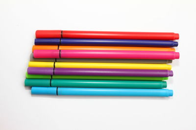 Close-up of colored pencils over white background