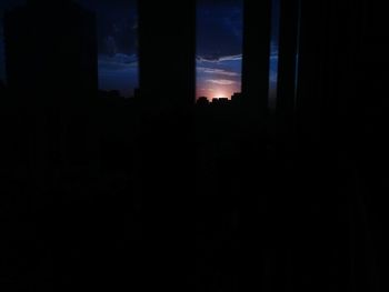 Silhouette buildings against sky at night