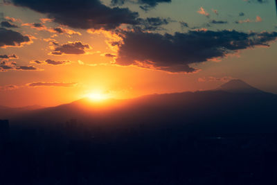 Scenic view of silhouette mountains against romantic sky at sunset