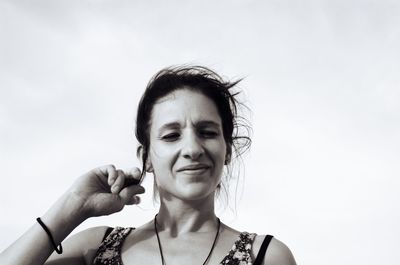 Portrait of young woman with text against sky