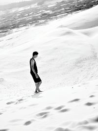 Side view of man walking on sand dune