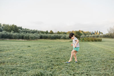 Full length of woman standing on field against sky