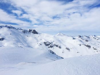 Scenic view of snow covered mountains against sky