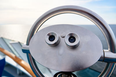 Close-up of coin-operated binoculars against sky