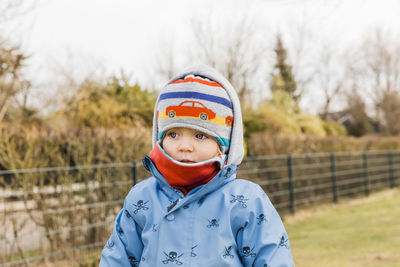 Cute girl wearing warm clothes while looking away on field