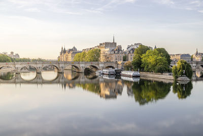 Paris bridge over river seine by buildings against sky