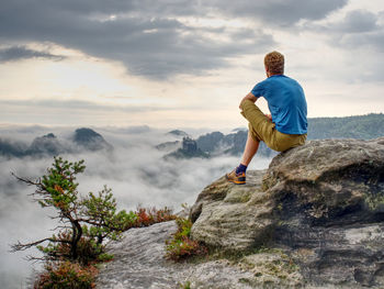 Top of rocky mountain with view into misty valley. foggy mountain peak. dreamy forest. sunrise cloud