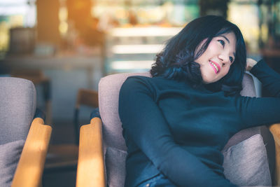 Portrait of smiling young woman sitting on seat