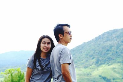 Friends standing against clear sky