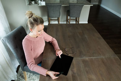 High angle view of woman using mobile phone at home